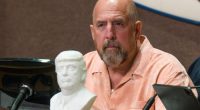 Huntington Beach mayor on dais with Trump bust in front of him