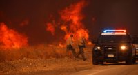 County Sheriff officers return to their vehicle during the Hughes Fire in California Jan. 22, 2025.