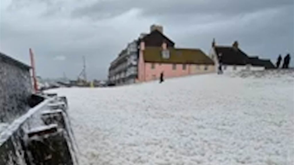 Moment tsunami of sea foam covers beach as Storm Herminia powers across Britain and forecasters warn of new 80mph winds hitting southern England and spreading north due to 'separate' threat