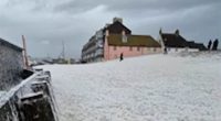 Moment tsunami of sea foam covers beach as Storm Herminia powers across Britain and forecasters warn of new 80mph winds hitting southern England and spreading north due to 'separate' threat