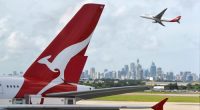 "Sydney, Australia - March, 14th 2012: Qantas aeroplanes and tail fin with the distant view of downtown Sydney - Sydney Airport"