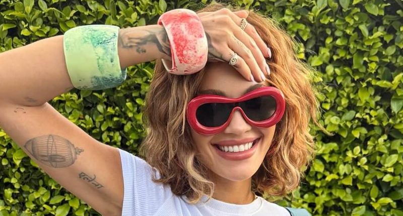 Rita Ora shows off her taut midriff in a stylish white crop top and light blue denim jeans from her Primark range during New Zealand getaway