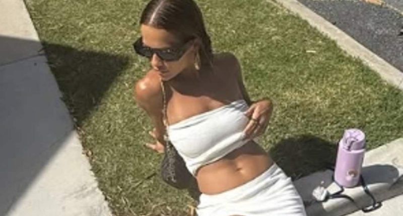 Rita Ora shows off her washboard abs in a skimpy white two-piece as she sunbathes on the pavement during New Zealand getaway
