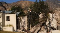 A worker services a utility pole in the aftermath of the Eaton Fire on Monday, Jan. 13, 2025, in Altadena, Calif. (AP Photo/Carolyn Kaster)