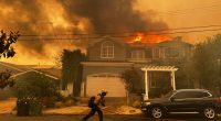 Thousands flee as wildfires burn out of control in and around Los Angeles and homes are destroyed