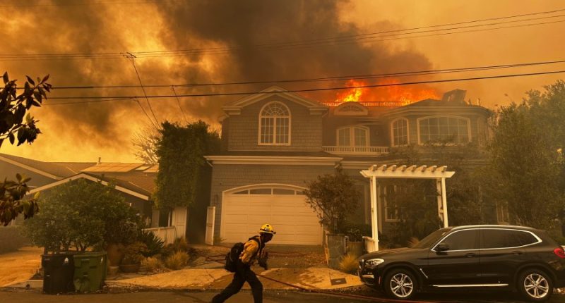 Thousands flee as wildfires burn out of control in and around Los Angeles and homes are destroyed