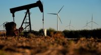 FILE - Pumpjacks operate in the foreground as the Buckeye Wind Energy wind farm rises in the distance, Sept. 30, 2024, near Hays, Kan. (AP Photo/Charlie Riedel, File)