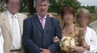 Man in a suit at a wedding with blurred faces of other attendees.
