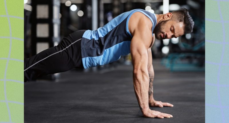 fit, muscular man doing pushups in dark gym