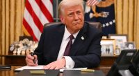 President Trump signing executive orders in the Oval Office.