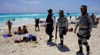 Mexican Navy and National Guard patrolling a beach with spring breakers.