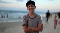 Smiling boy on a beach.