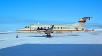 Beechcraft B1900D passenger airliner on a snowy airfield.