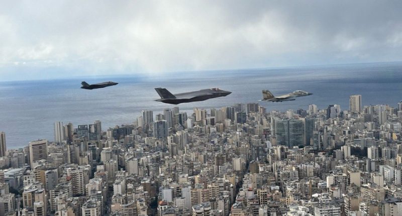 Three Israeli warplanes flying low over a city near the coast.