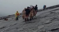 Rescuers carrying an injured climber down a mountain.