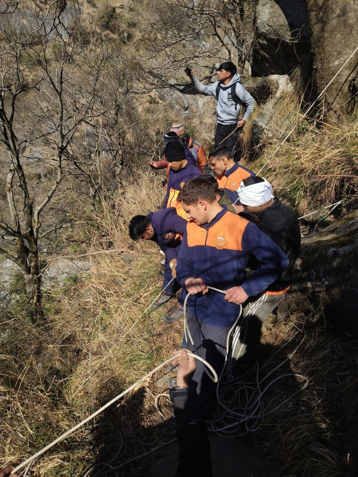 Rescue team using ropes in a mountainous area.