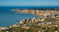 Aerial view of Fuengirola, Spain, showing the coastline, city, and surrounding hills.