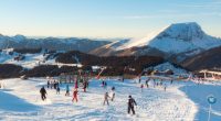 Skiers and snowboarders on a sunny blue piste in the Avoriaz/Morzine ski area.