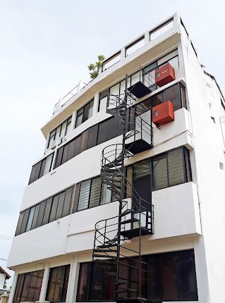 White building with exterior spiral staircase.