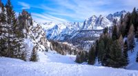 Snowy Dolomites mountain range with ski slope.