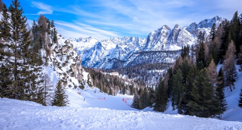 Snowy Dolomites mountain range with ski slope.