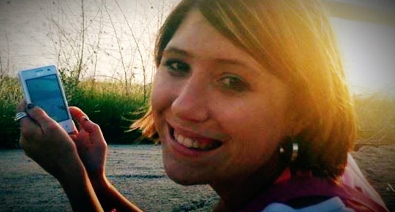 Photo of a young woman holding a cell phone.