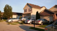 Cars parked in the driveways of homes.