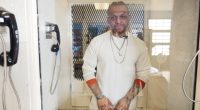 A death row inmate in a prison visiting booth.