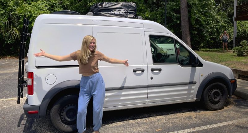 Gabby Petito standing next to her white van.