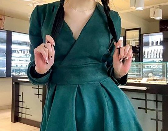 Woman in teal dress and glasses.