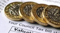 One pound coins on a council tax bill.