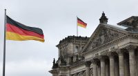 The Reichstag Building in Berlin with the German flag flying.