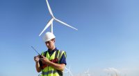 Technician using a walkie-talkie in a wind farm.