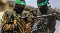 Hamas fighters with a machine gun and ammunition belt during a prisoner exchange.