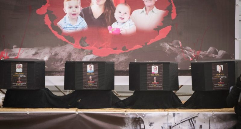 The coffins containing the bodies, from right to left, Shiri Bibas, her two children, Ariel and Kfir and Oded Lifshitz, who was 83 when he was abducted, are displayed on a stage before being handed over to the Red Cross by Hamas and Islamic Jihad in Khan Younis, southern Gaza Strip, Thursday, Feb. 20, 2025. (AP Photo/Abdel Kareem Hana)