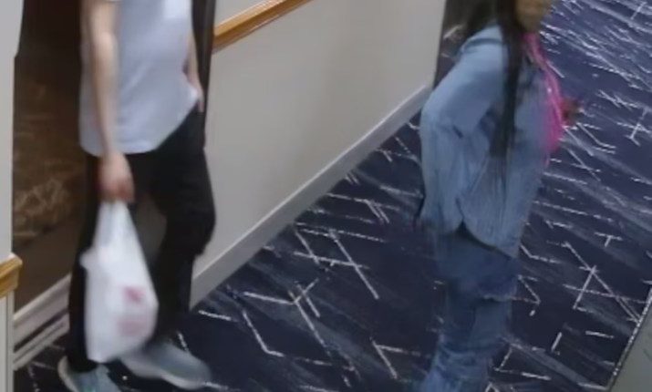 Security camera image of a man and woman in a hotel hallway.