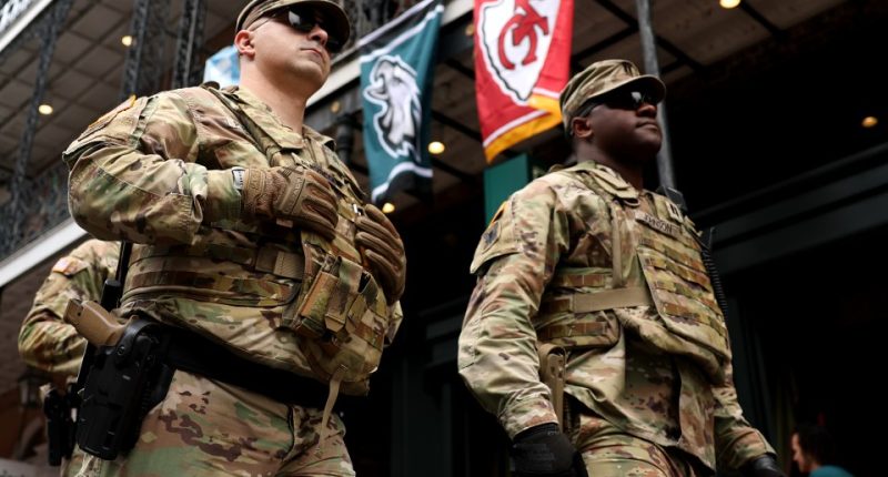 Two soldiers in camouflage uniforms stand in New Orleans.