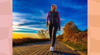 fit woman walking outdoors at sunset along path by the beach