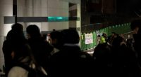 People gathered outside a South Korean elementary school at night following a student's death.