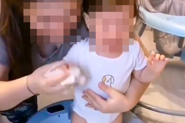 A mother puts her son in a tub of snow.