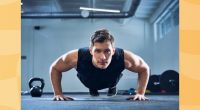 man doing pushups in a dark gym