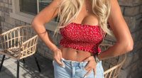 Woman in red crop top and light wash jeans.