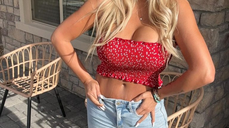 Woman in red crop top and light wash jeans.