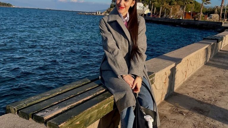 Woman sitting on a bench by the sea.