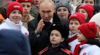 MOSCOW, RUSSIA - NOVEMBER 4: (RUSSIA OUT) Russian President Vladimir Putin poses with children of Russian officers, who are taking part in the military invasion of Ukraine and to participants of youth and student organizations, at the Red Square on November 4, 2024 in Moscow, Russia. Putin put flowers on the monument to Minin and Pozharsky, marking the National Unity Day. (Photo by Contributor/Getty Images)