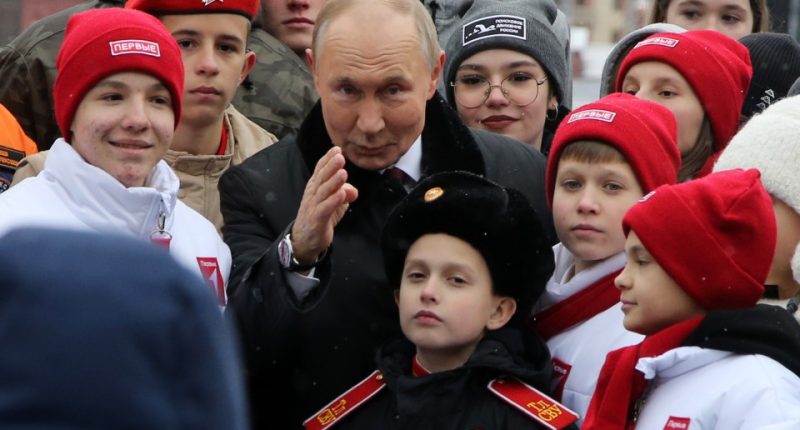 MOSCOW, RUSSIA - NOVEMBER 4: (RUSSIA OUT) Russian President Vladimir Putin poses with children of Russian officers, who are taking part in the military invasion of Ukraine and to participants of youth and student organizations, at the Red Square on November 4, 2024 in Moscow, Russia. Putin put flowers on the monument to Minin and Pozharsky, marking the National Unity Day. (Photo by Contributor/Getty Images)