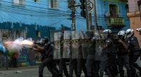 Police officers in riot gear firing weapons in Sao Paulo, Brazil.