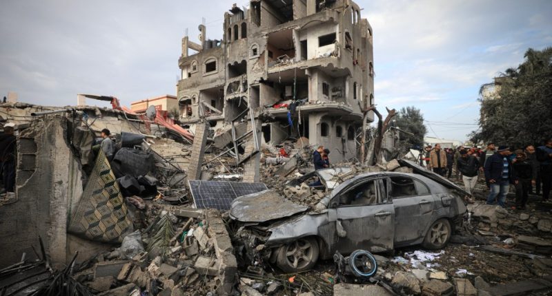 Palestinians inspect the damage at the Al-Maghazi refugee camp after an overnight Israeli strike on December 25, 2023, amid ongoing battles between Israel and the Palestinian militant group Hamas. (Photo by Mahmud HAMS / AFP) (Photo by MAHMUD HAMS/AFP via Getty Images)