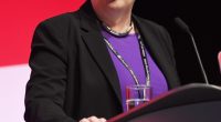 a woman is giving a speech at the labour party annual conference