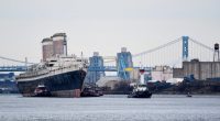 The SS United States being towed out to sea.